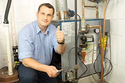 Service technician servicing heating equipment